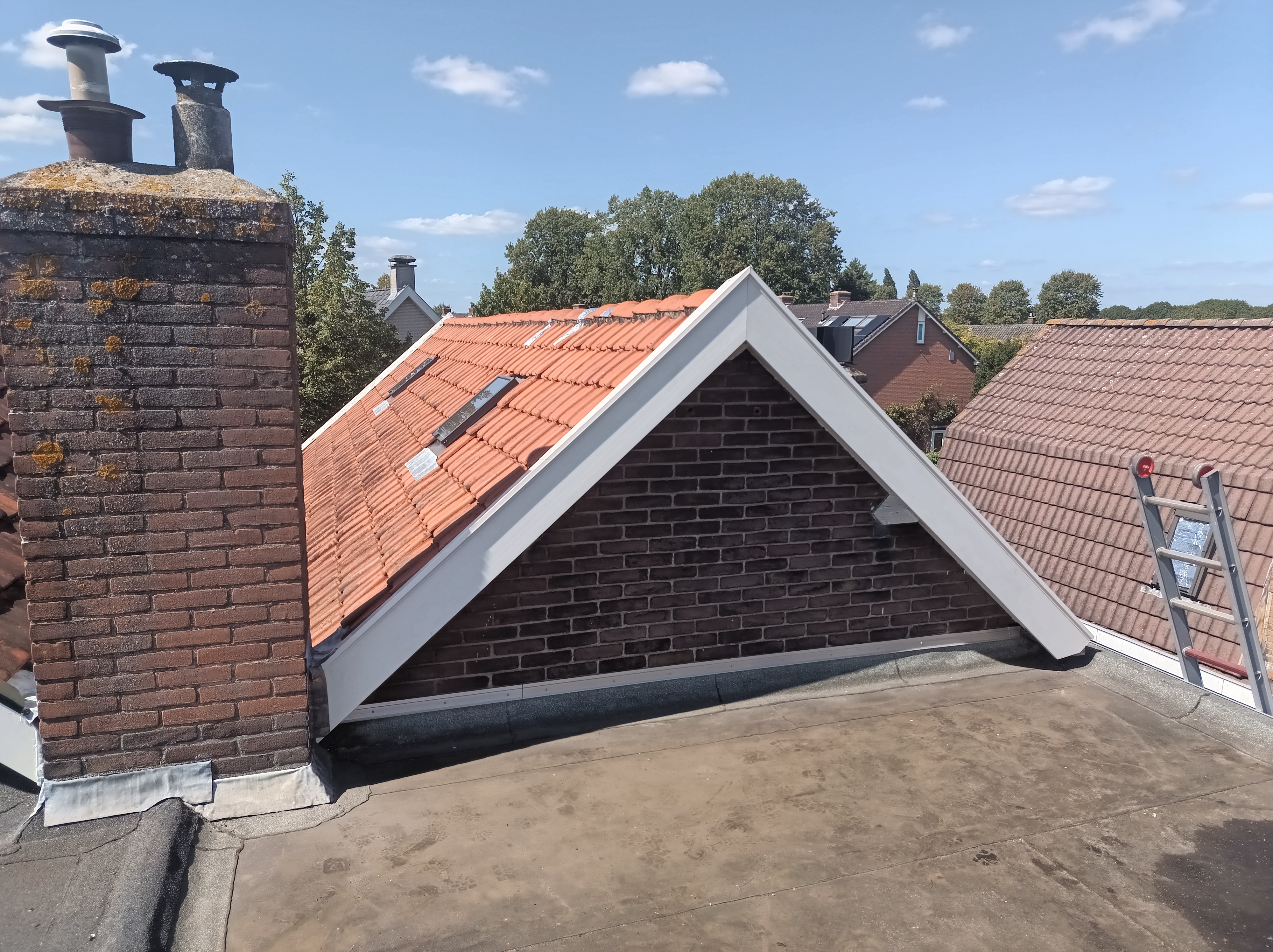 Afgewerkte windveren en dakranden bij een gemetselde gevel